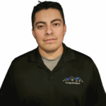 Professional headshot of young man in dark green polo shirt with company logo